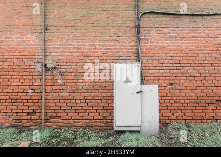 The old broken electrical panel or box on the wall. Industrial Abandoned Power Control System. Stock Photo