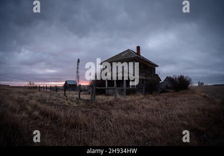 Abandoned and broken down old farms and homesteads with dark and ominous skies in Alberta, Canada Stock Photo