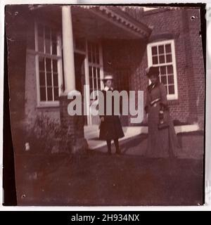Vintage faded out of focus  photograph of Mother and daughter outside house, English, anonymous, 1910s