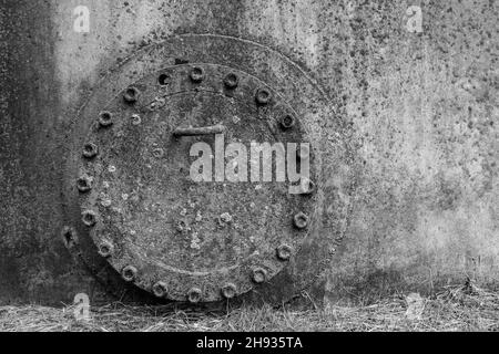 Old dirty fuel hatch for cleaning from liquid chemical waste and oil of an abandoned tank industrial plant. Stock Photo