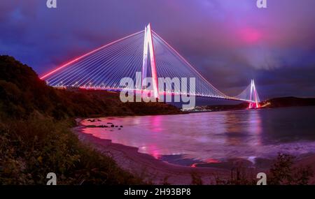Yavuz Sultan Selim Bridge in evening illumination. Suspension bridges in İstanbul, Turkey. Long exposure, Violet, purple cloudy sky Background. Stock Photo