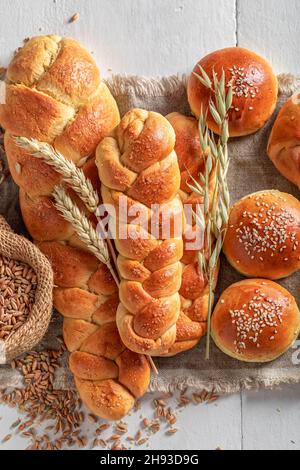 Golden buns and challahs freshly baked in home bakery. Variety of homemade breads. Stock Photo