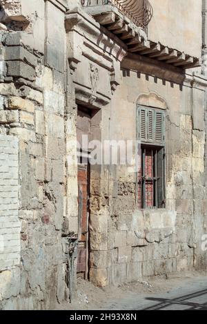 Grunge stone bricks wall with Broken wooden door and closed broken window in abandoned district Stock Photo