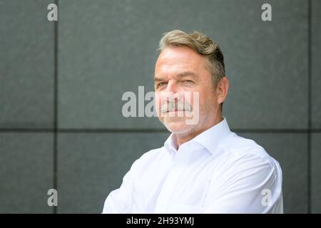Side view portrait of smiling confident middle aged businessman in shirt Stock Photo
