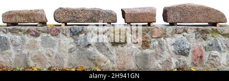 A roughly cut granite stones for staircase lie on village fence. Isolated on white Stock Photo