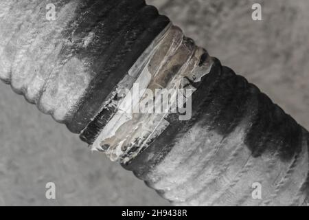 Broken pipe of leaking pipeline of the heating main damaged old industrial tube. Stock Photo