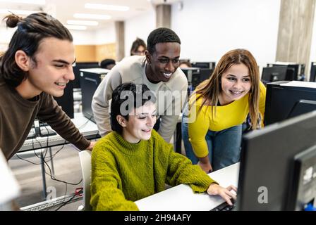 Young classmates studying together inside classroom - Education concept Stock Photo