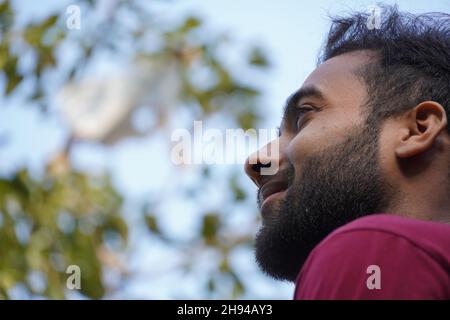 Half-turned side profile close up view portrait of handsome virile masculine attractive confident smart intelligent clever indian man Stock Photo