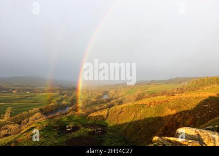 Middleton-in-Teesdale, County Durham, UK.  4th December 2021. UK Weather.  A spectacular rainbow appears over the Tees valley as heavy rain, sleet and snow showers sweep into Upper Teesdale where teams are still working to bring electricity to homes cut off during storm Arwen 8 days ago.  Credit: David Forster/Alamy Live News Stock Photo