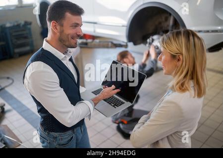 Caucasian woman getting her car fixed at the mechanic Stock Photo