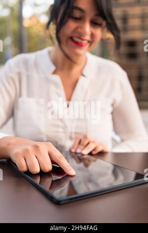 vertical photo of a woman using digital tablet, focus on the device, concept of digital entrepreneur and urban lifestyle, copy space for text Stock Photo