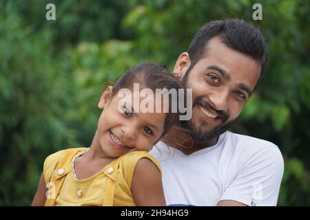 A boy who has adopted a cute girl ,both of whom are smiling Stock Photo