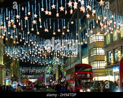 View looking up at the festive Christmas lights at night in Oxford Street London 2021 Stock Photo