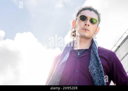 A Portrait from a low angle view of a Young Latino man with serious expression. Copy space. Stock Photo