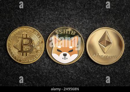 Shiba Inu Coin between Bitcoin and Ethereum physical coins Stock Photo