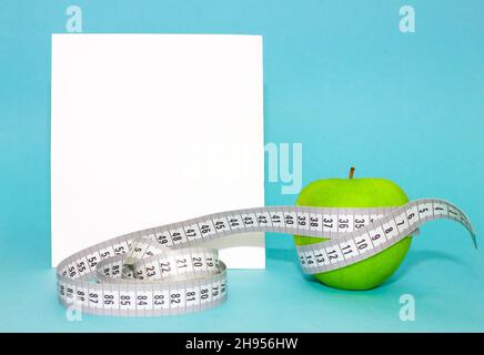 Close-up of green apple centimeter tape on blue background for conceptual design. Lifestyle, food concept Stock Photo