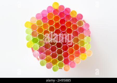 Colorful drink straws on white background. Colored tubules for juice and cocktails. Top view. Stock Photo