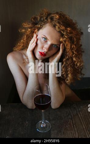 Portrait Photographie einer schönen jungen Frau mit Roten Haaren, Sommersprossen, sinnlichen Blick, erotischen roten Lippen und blauen Augen Stock Photo