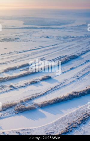 Aerial view of floodplain of great river on the snow-covered plain in time of winter morning. Stock Photo