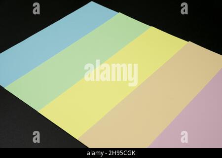 Pastel-colored paper background on black surface with space for text Stock Photo