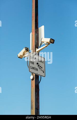 Two surveillance cameras on the metal street light lamp post outdoor on ...