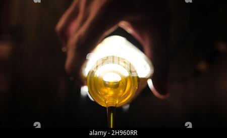 Extreme macro of olive oil poured from an original bottle. Stock footage. Close-up of oil pouring out of the bottle. Stock Photo