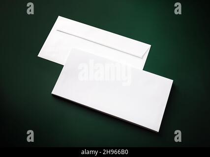 Two blank white envelopes on green background. Copy space. Stock Photo