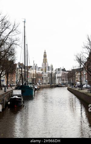 A cloudy November day along the canal at Hoge der A in Groningen, Netherlands. The Aa-kerk is in the distance. Stock Photo