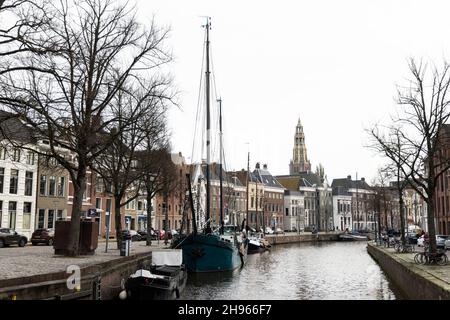 A cloudy November day along the canal at Hoge der A in Groningen, Netherlands. The Aa-kerk is in the distance. Stock Photo