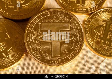 Concept of Tether coin against golden bitcoin coins. Tether is backed by US dollar and used for trading in alt coins Stock Photo