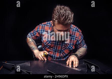 Worker of leather producing leather workpiece Stock Photo