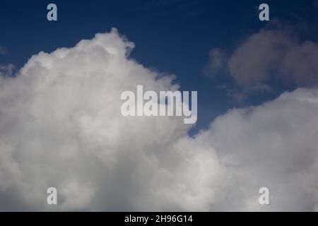 Cloudscape with fluffy white clouds against a deep blue sky Stock Photo