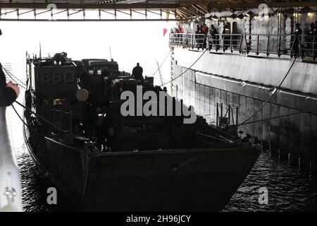 A landing craft, utility enters the well deck of amphibious dock ...