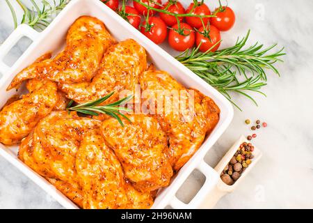 Chicken wings are raw in the marinade. Grilled chicken wings recipe. Stock Photo