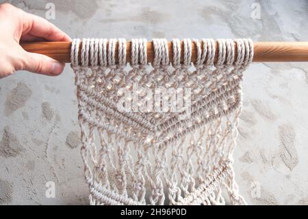 Boho macrame wall decor for a cozy atmosphere in the hands Stock Photo