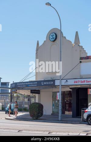 Part of a larger strip of shops, the Mark Mayne (Dry Cleaners) clock is mounted on an ornate parapet near the railway station at Lindfield, Sydney Stock Photo
