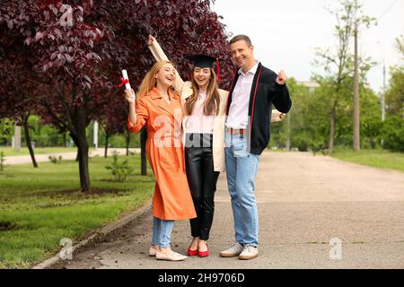 Happy young woman with her parents on graduation day Stock Photo