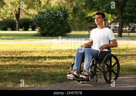 Young man with physical disability in park Stock Photo