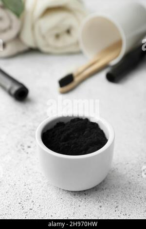 Bowl with activated charcoal tooth powder on light background Stock Photo