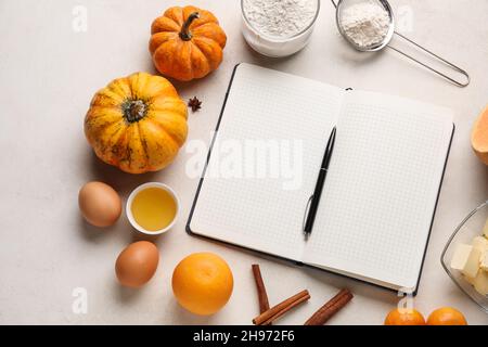 Recipe book and ingredients for pumpkin pie on white background Stock Photo