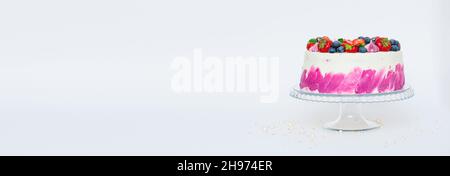 Delicate cake decorated with fresh berries strawberries blueberries white plain background. Festive dessert with berries Stock Photo