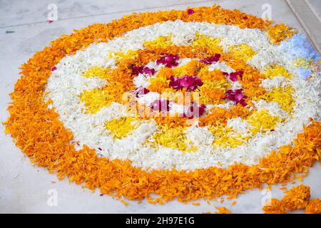 Rangoli pookalam pattern made of flower petals on teh ground for religious celebrations like diwali, christmas and new year Stock Photo