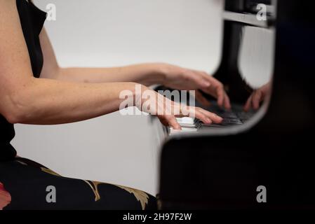 Female hands playing piano, close-up photo Stock Photo