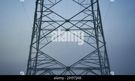 Detail from a Electricity pylon (Strommasten) also overhead line pylon in foggy Winter morning. Front View. Stock Photo