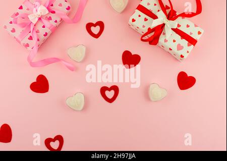 top view of the pink background with festive valentine's day boxes, red hearts and heart-shaped candles Stock Photo