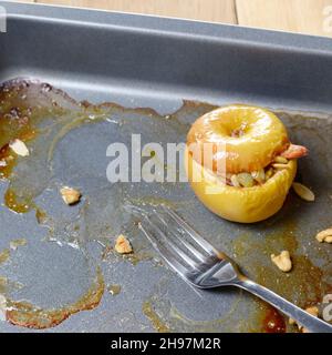Homemade oven baked apples stuffed with pumpkin seeds and almond nuts in baking pan closeup Stock Photo