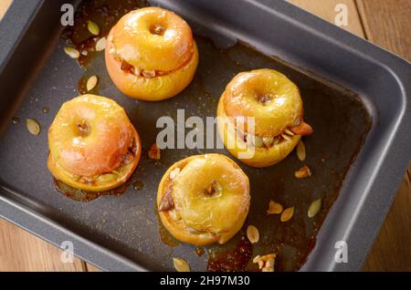 Homemade oven baked apples stuffed with pumpkin seeds and almond nuts in baking pan closeup Stock Photo