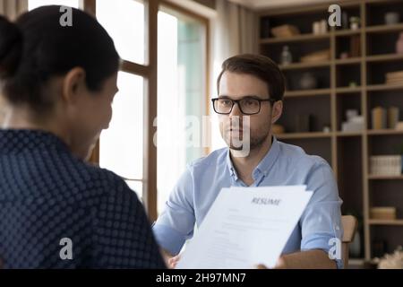 Female company leader, director, recruiter reviewing paper resume Stock Photo