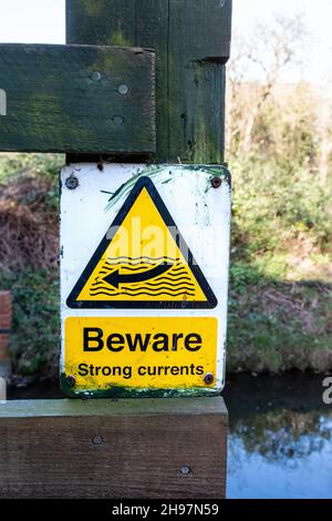 A warning sign telling passers by to Beware Strong Current at the Stapleford Gauging Station on the River Granta. Stock Photo