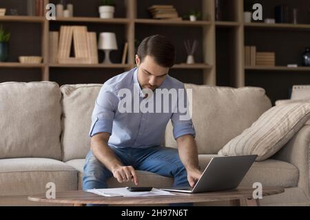 Serious homeowner man using accounting financial banking online app Stock Photo